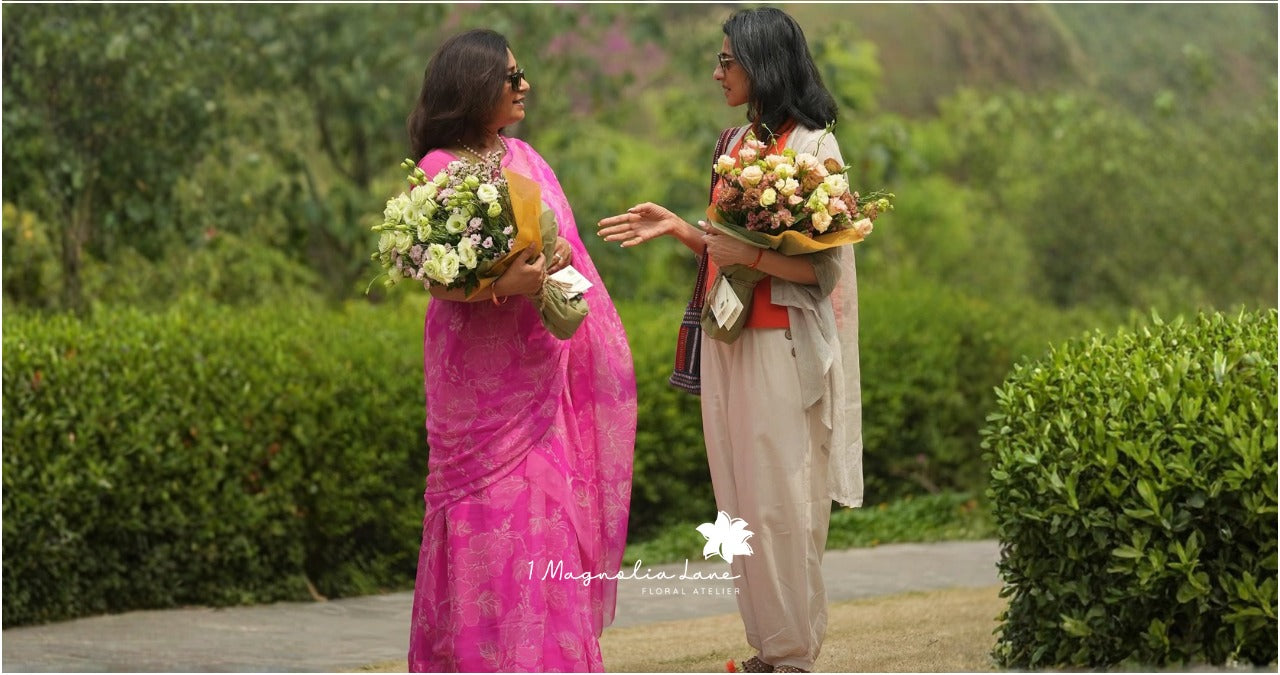 Two women holding large colorful bouquets for Mother's Day celebrations